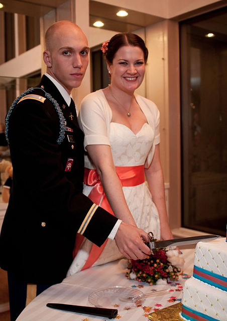 military groom and bride cake cutting