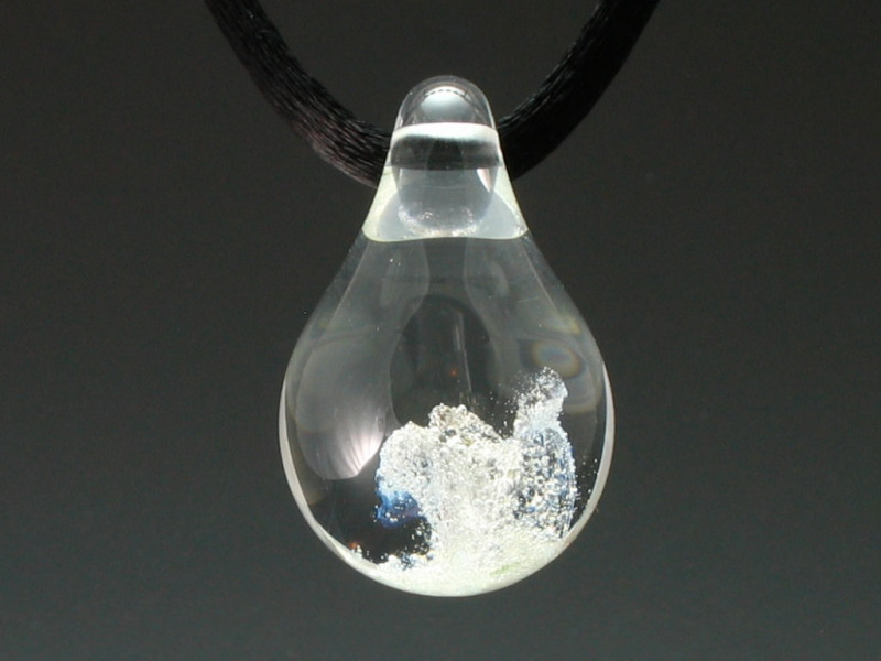 This tear-drop pendant is hand blown glass that includes the preserved ashes of your loved one. The ashes are encased in hot molten glass and sealed inside a memorial pendant, forever capturing their energy in a beautiful piece of cremation jewelry.