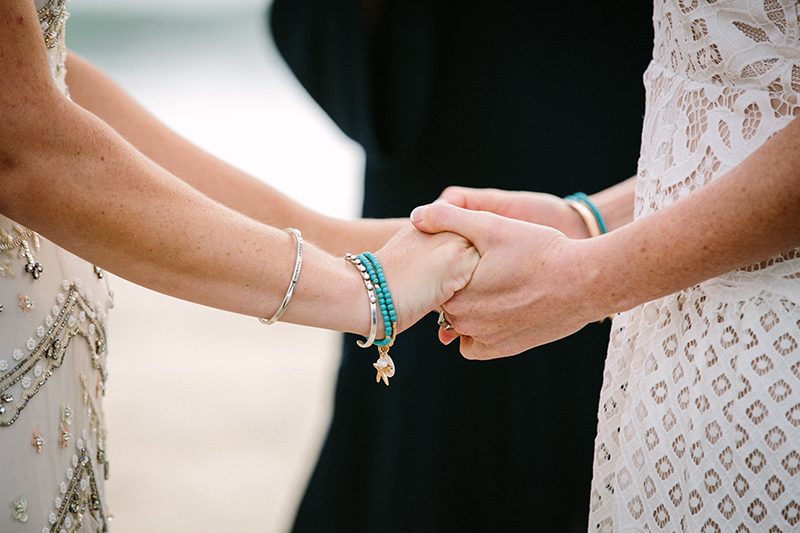 An aerial silk chuppah and two stunning gowns at this sweet beach wedding