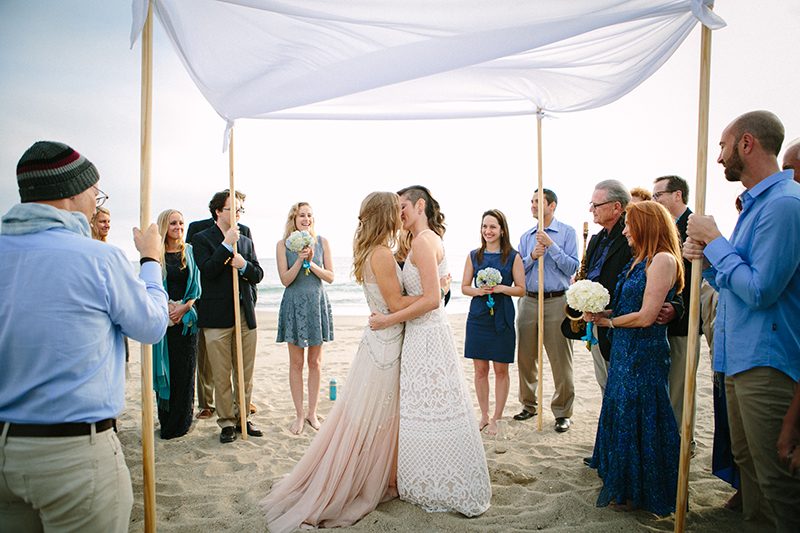 An aerial silk chuppah and two stunning gowns at this sweet beach wedding