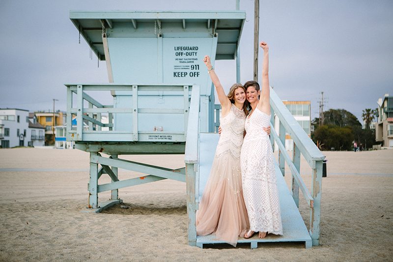 An aerial silk chuppah and two stunning gowns at this beach wedding