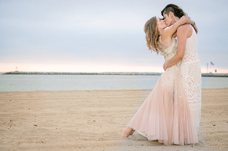 An aerial silk chuppah and two stunning gowns at this beach wedding