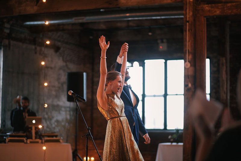 A gold dress wedding with karaoke, and tacos all wrapped up in fairy lights
