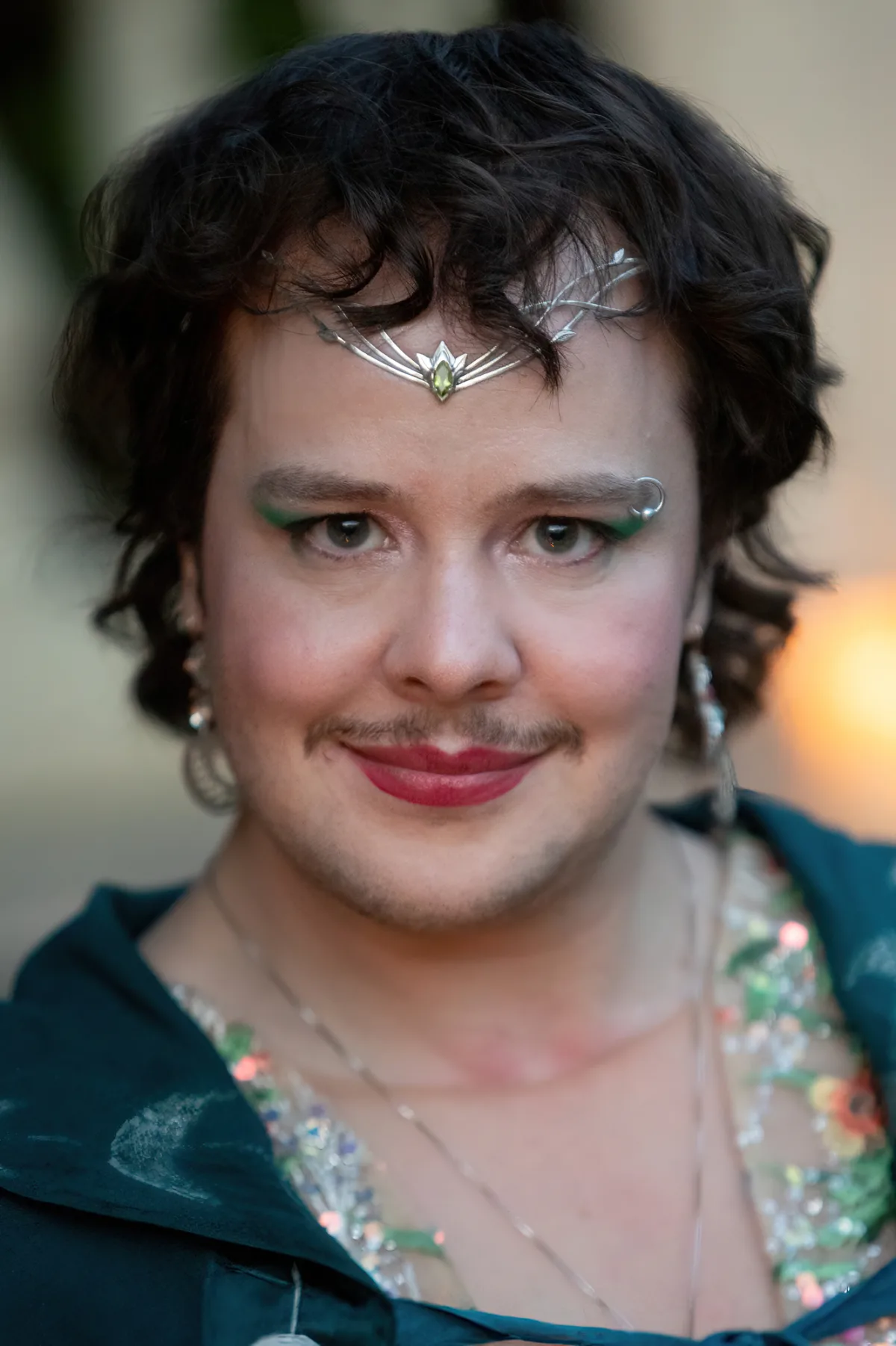 A non-binary newlywed wears a crown and a mustache at their wedding in the Hudson Valley.