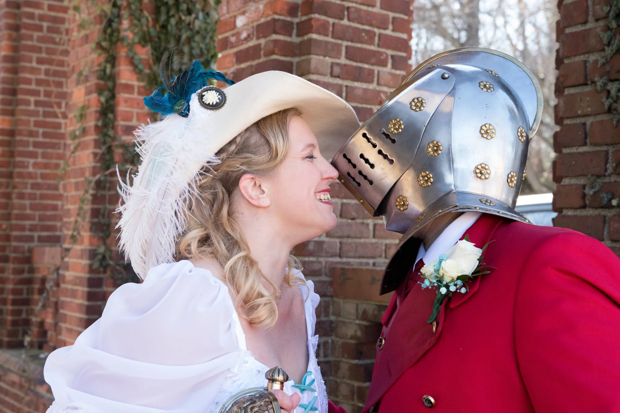 A married couple in Red Faire garb smile at their Hudson Valley wedding.