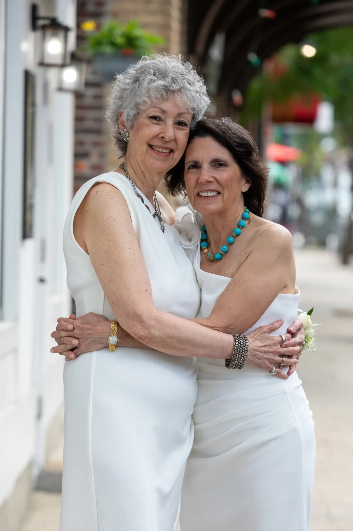 Two older brides embrace at their New York lesbian wedding.