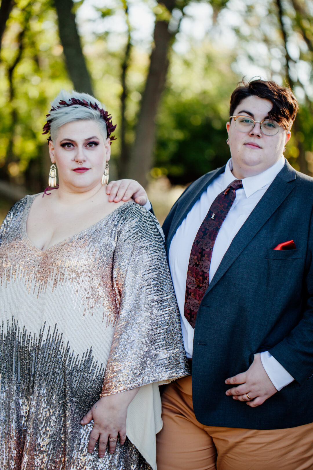 queer bride in metallic sequin caftan with nonbinary spouse in suit and tie