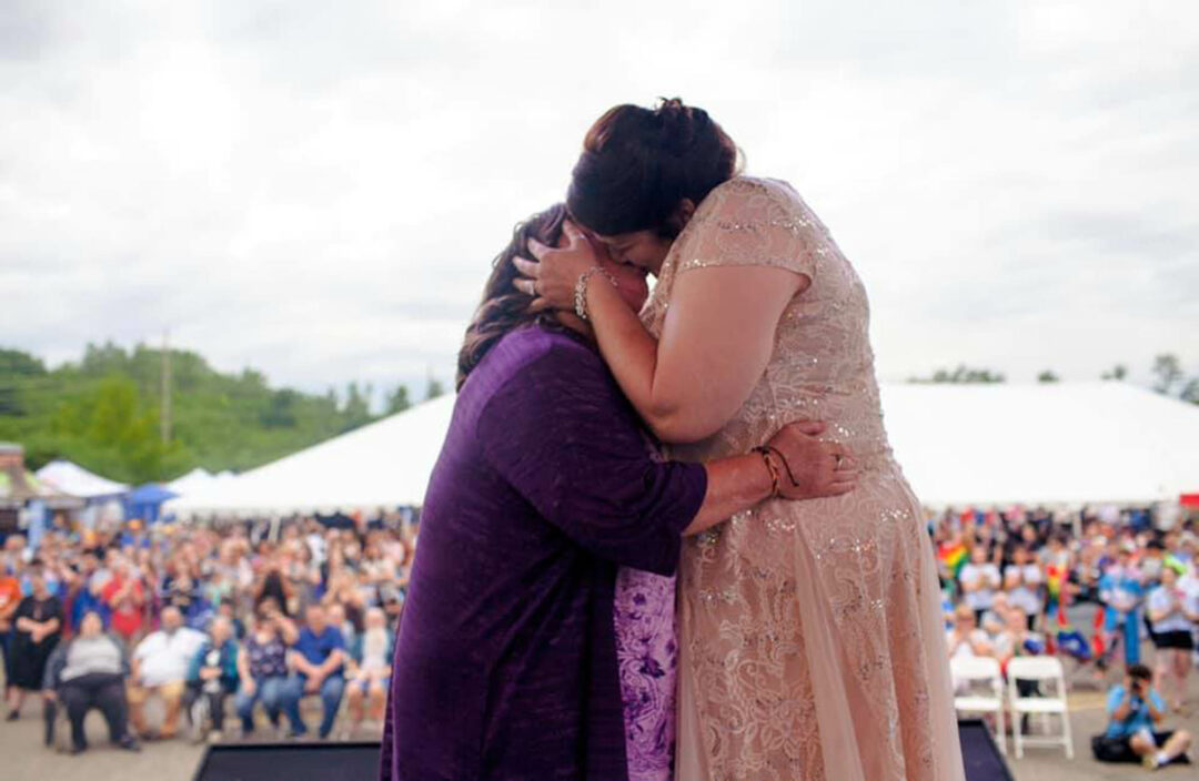 two brides kiss during wedding ceremony at LGBTQ Pride