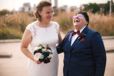 LGBTQ couple laughing together outside the courthouse.