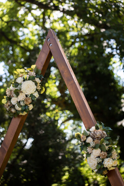 Wooden triangle arch with two swags of wood flowers.