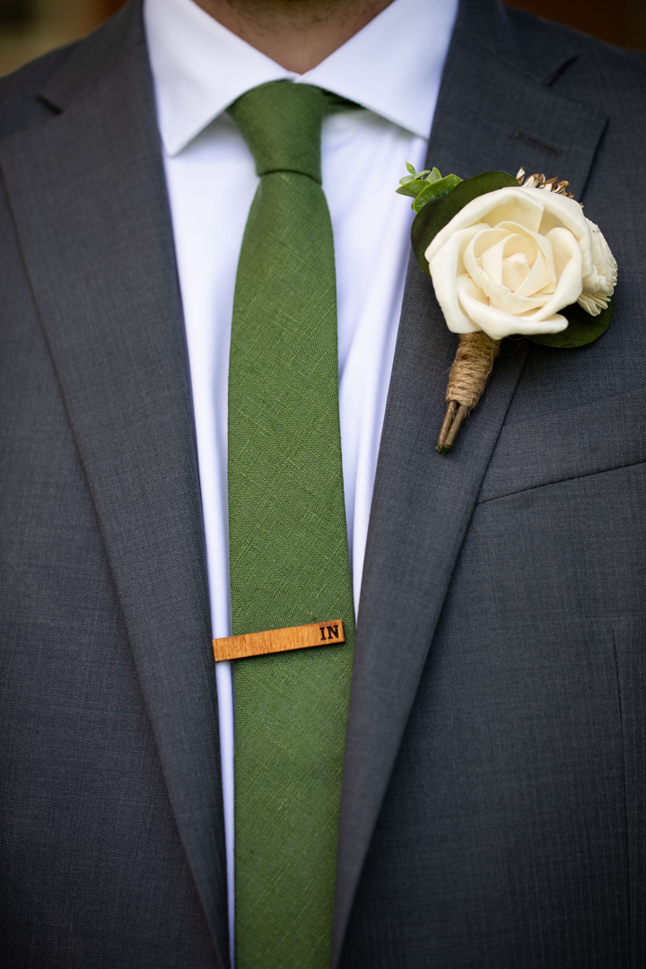 Close up of boutonniere - it is a wooden rose with twine-wrapped stems.