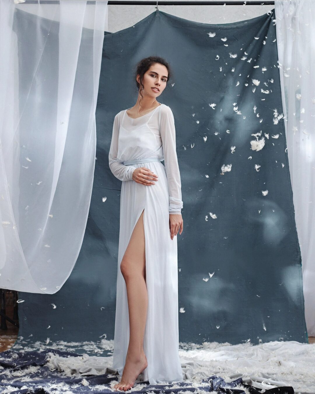 Simple wedding dress with boat neck, open back, full sleeves, and leg slit