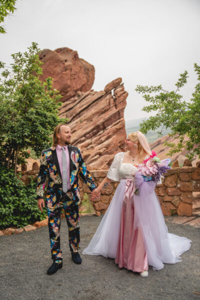 Couple sanding in fun funky, unique wedding attire at red rocks.