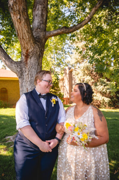 LGBTQ+ couple standing under oak trees