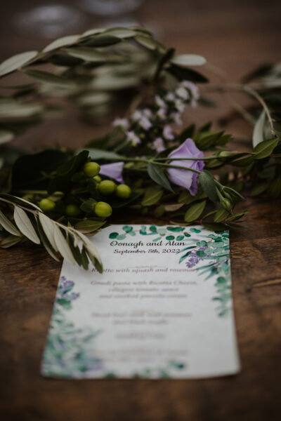 Lilac flowers, olive leaves for the table wreath, and the menu, in purple and green hues.