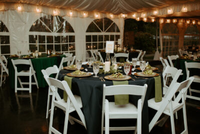 Dining tables set at a wedding reception at the Victorian Belle Mansion in Portland, Oregon. The tables have blue tablecloths and green napkins. Photo by Hannah Alena