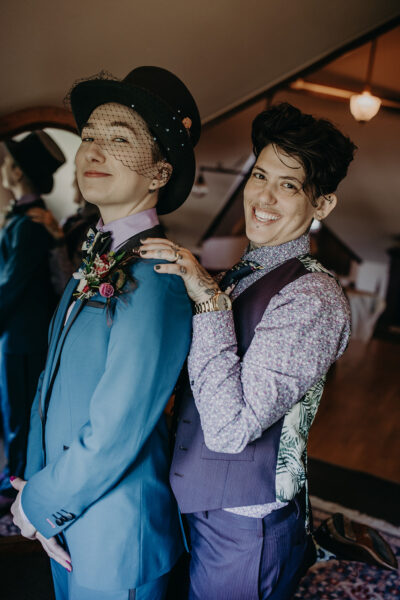 Two people in suits stand together smiling