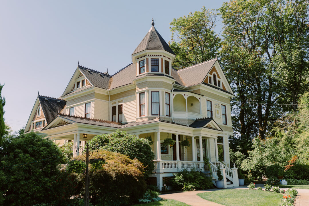 Ornate Victorian Mansion surrounded by trees, shrubs, and gardens
