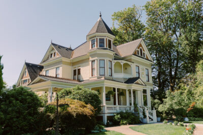 Ornate Victorian Mansion surrounded by trees, shrubs, and gardens