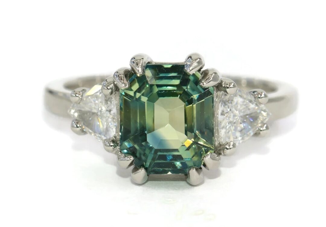 Ships from California! Shorter shipping distances are kinder to the planet Materials: Diamond, Gemstone, Gold, Platinum, Sapphire Sustainable features: recycled metal, upcycled. Items may include additional materials or use methods that aren't considered sustainable features on our site. Learn more Gemstone: Sapphire Gem color: Green Band color: White Style: Art deco Can be personalized Recycled Made to Order