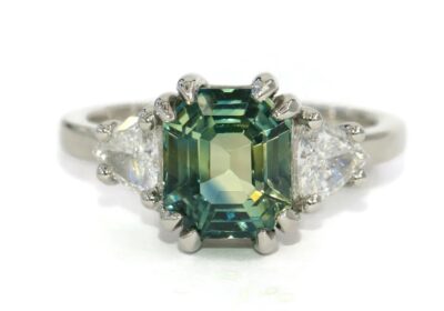 Ships from California! Shorter shipping distances are kinder to the planet Materials: Diamond, Gemstone, Gold, Platinum, Sapphire Sustainable features: recycled metal, upcycled. Items may include additional materials or use methods that aren't considered sustainable features on our site. Learn more Gemstone: Sapphire Gem color: Green Band color: White Style: Art deco Can be personalized Recycled Made to Order
