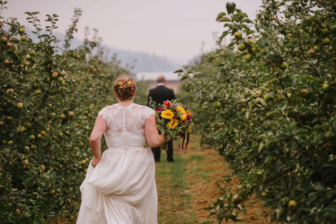 bride in the orchard facing away from camera