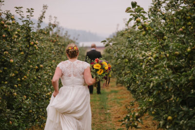 bride in the orchard facing away from camera