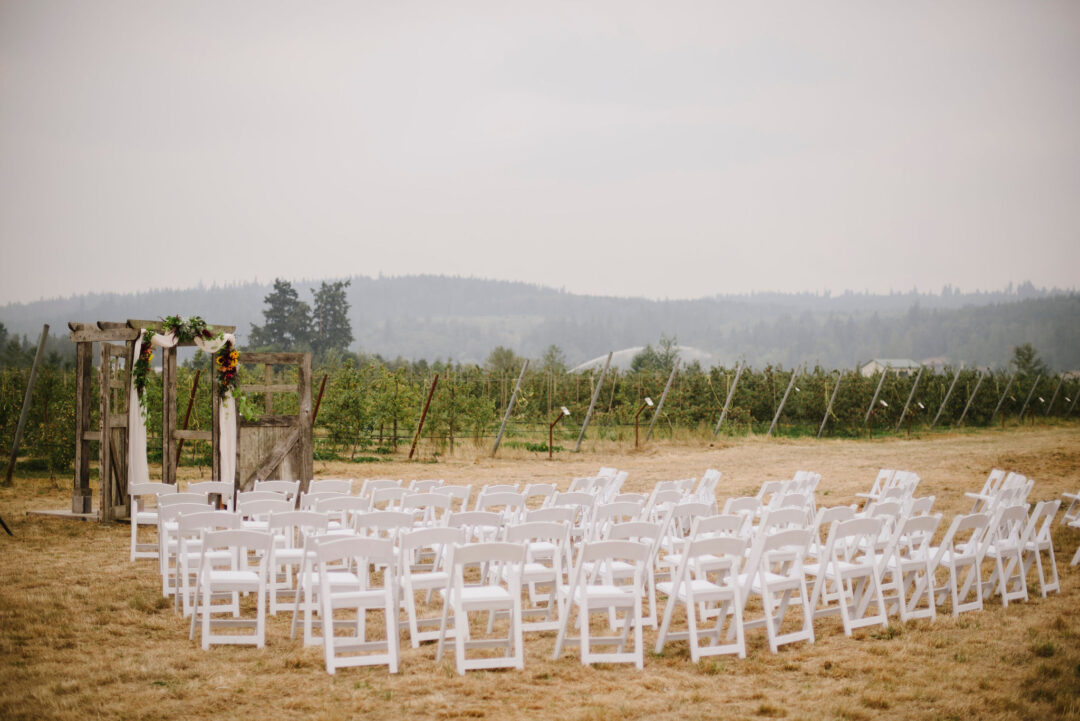 rows of chairs in the orchard for a wedding