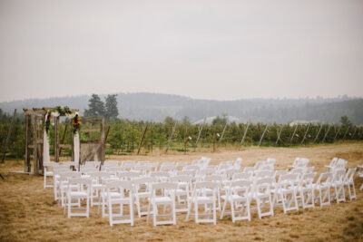 rows of chairs in the orchard for a wedding